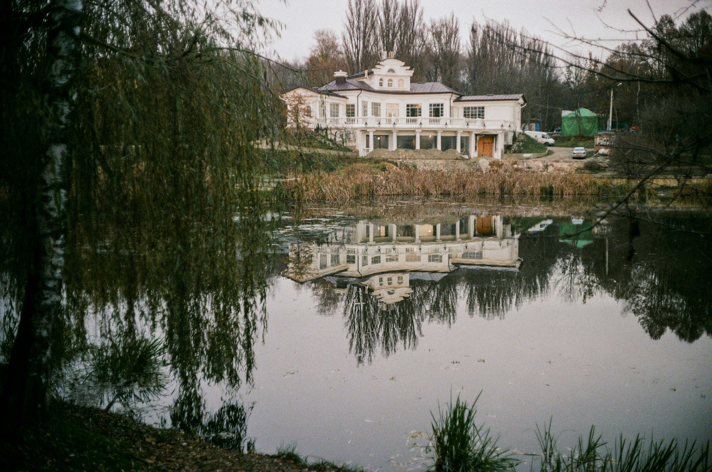 white concrete building near green trees and body of water during daytime